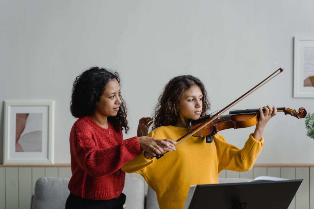 teacher showing the student how to hold a violin