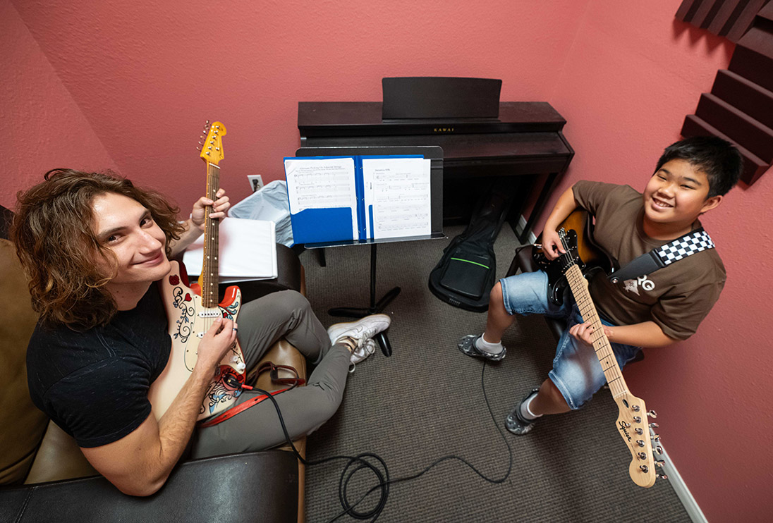Young boy learning guitar from a Brill Music Academy Teacher