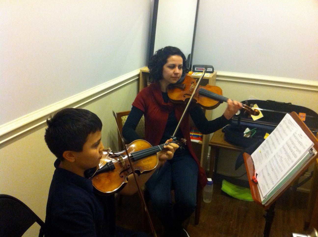 Violin student and teacher playing violin together