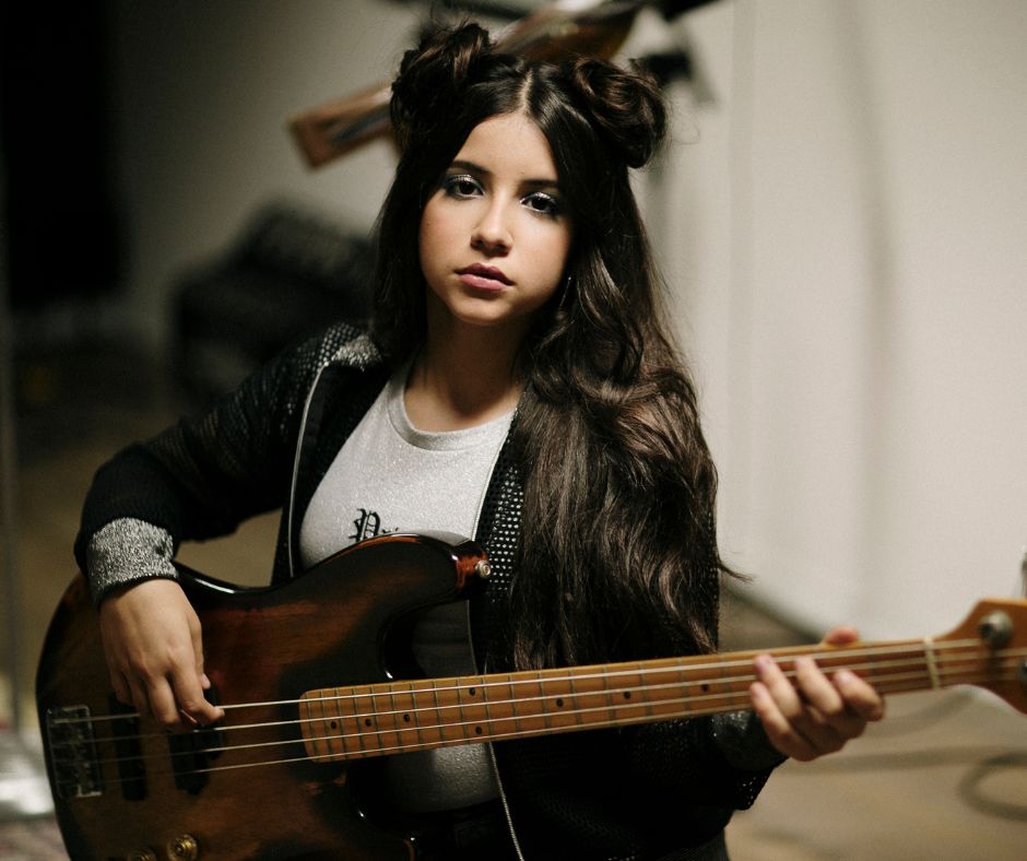 Girl playing bass guitar - cappella music academy