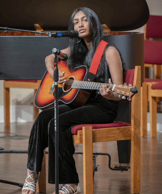 student playing the guitar and singing
