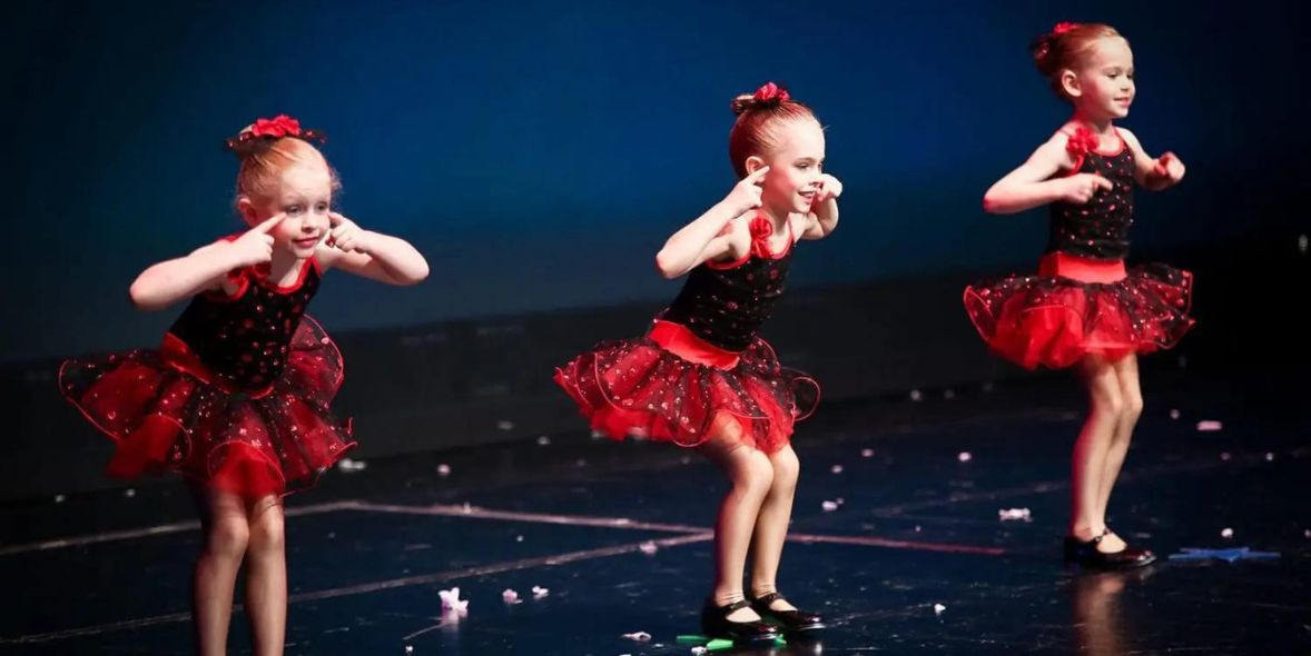 three cute girls performing dance on the stage