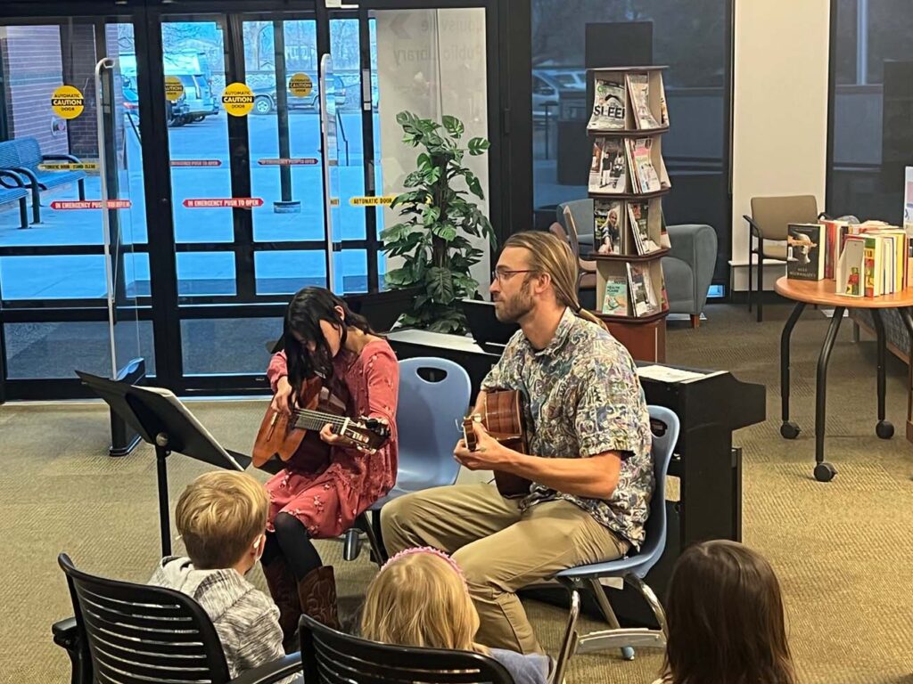 guitar teacher playing guitar with the student