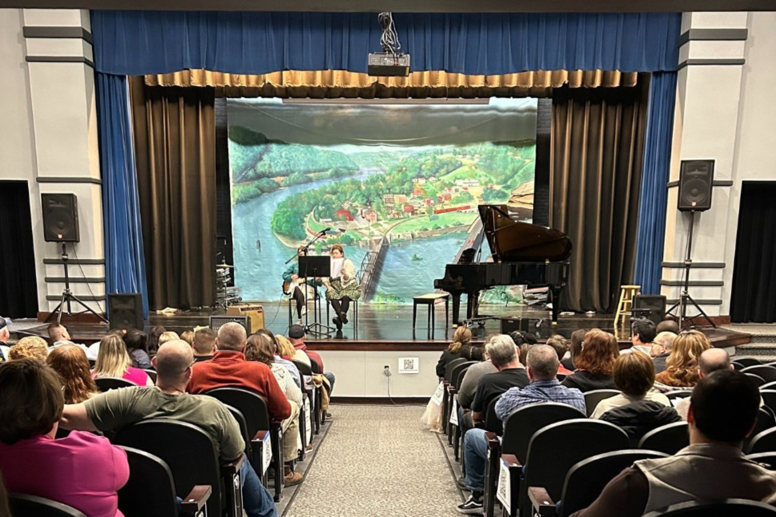 looking at a stage in an auditorium from the middle aisle