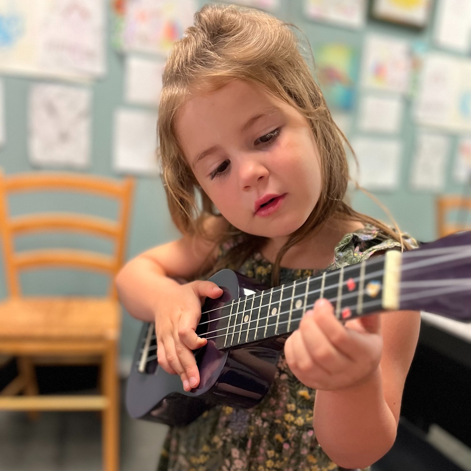 little girl playing ukulele