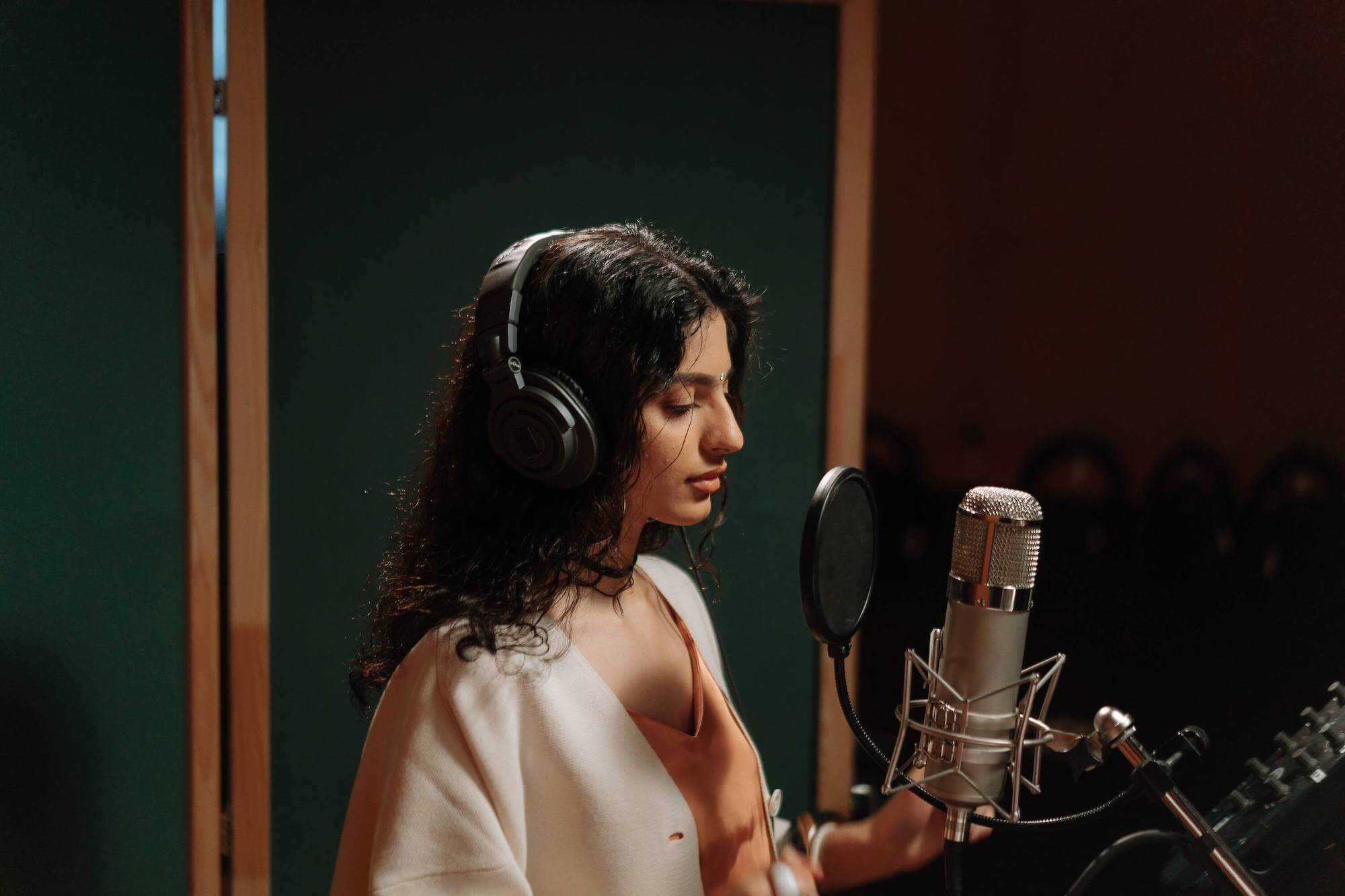 voice student singing into a microphone in a studio