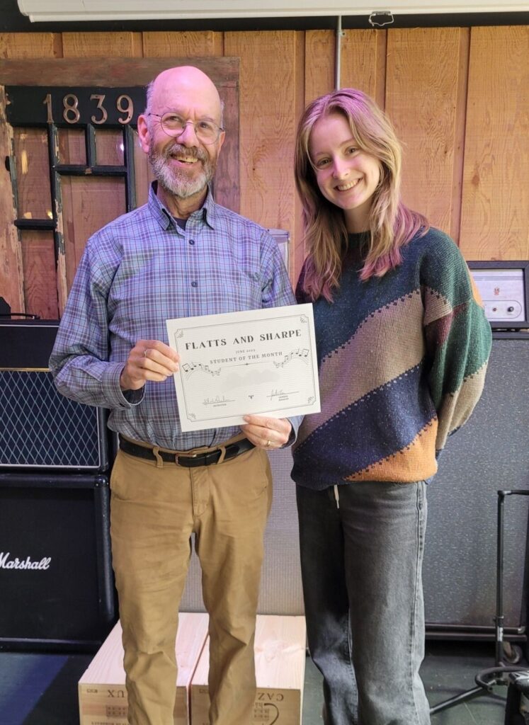 contact us hero teacher and student smiling holding an award