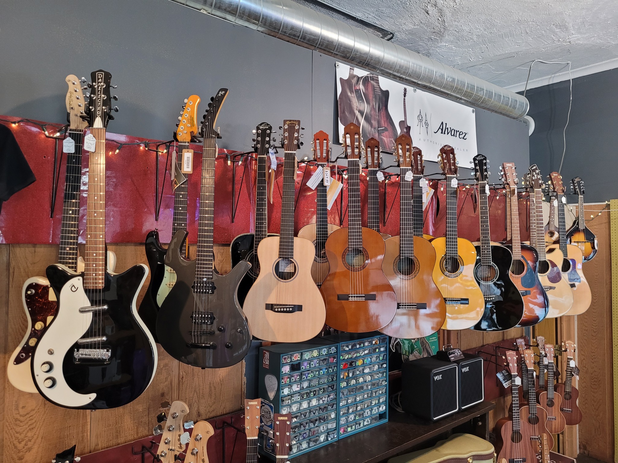 row of guitars hanging on the wall