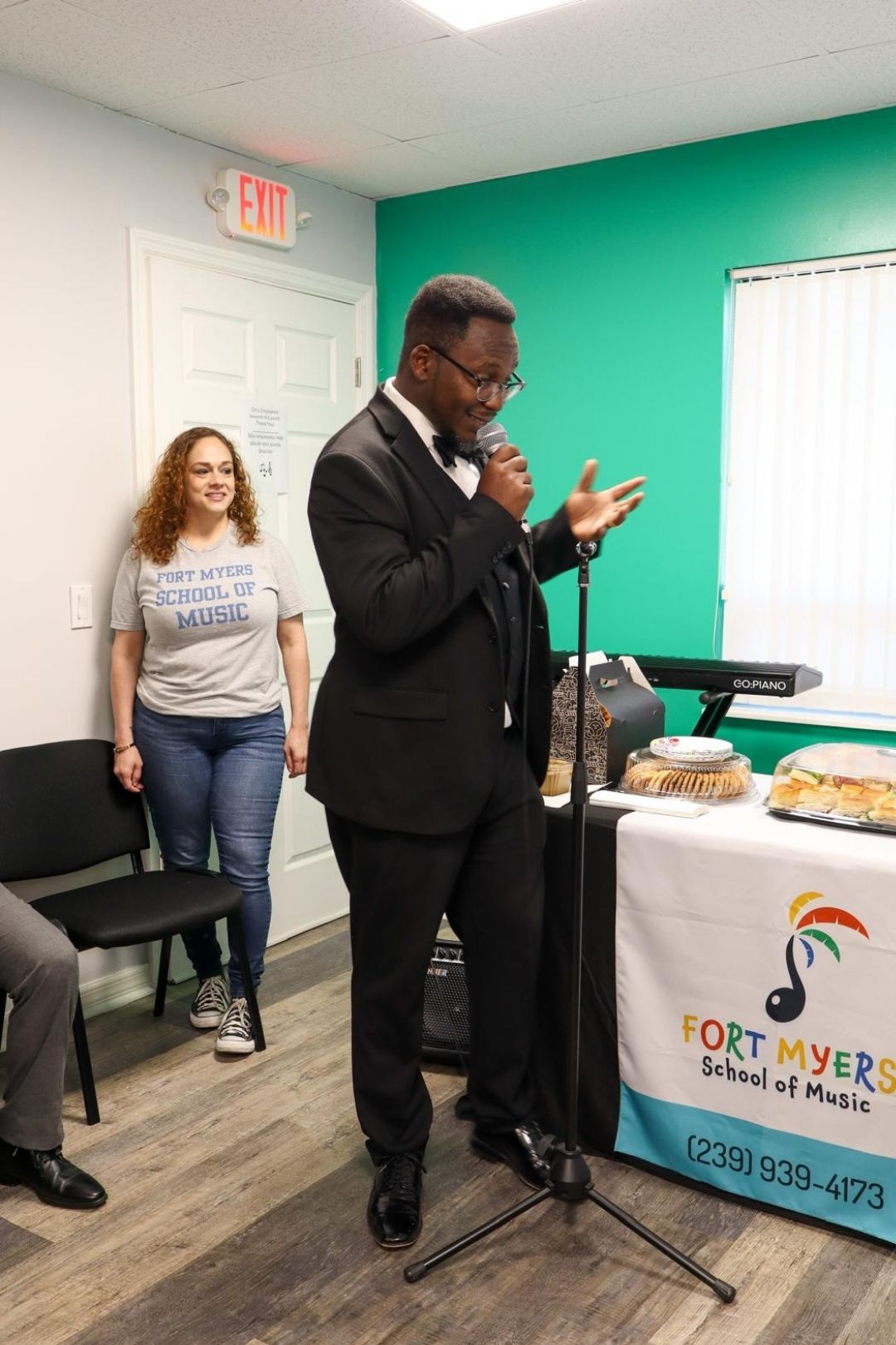 teacher in a suit singing during our open house