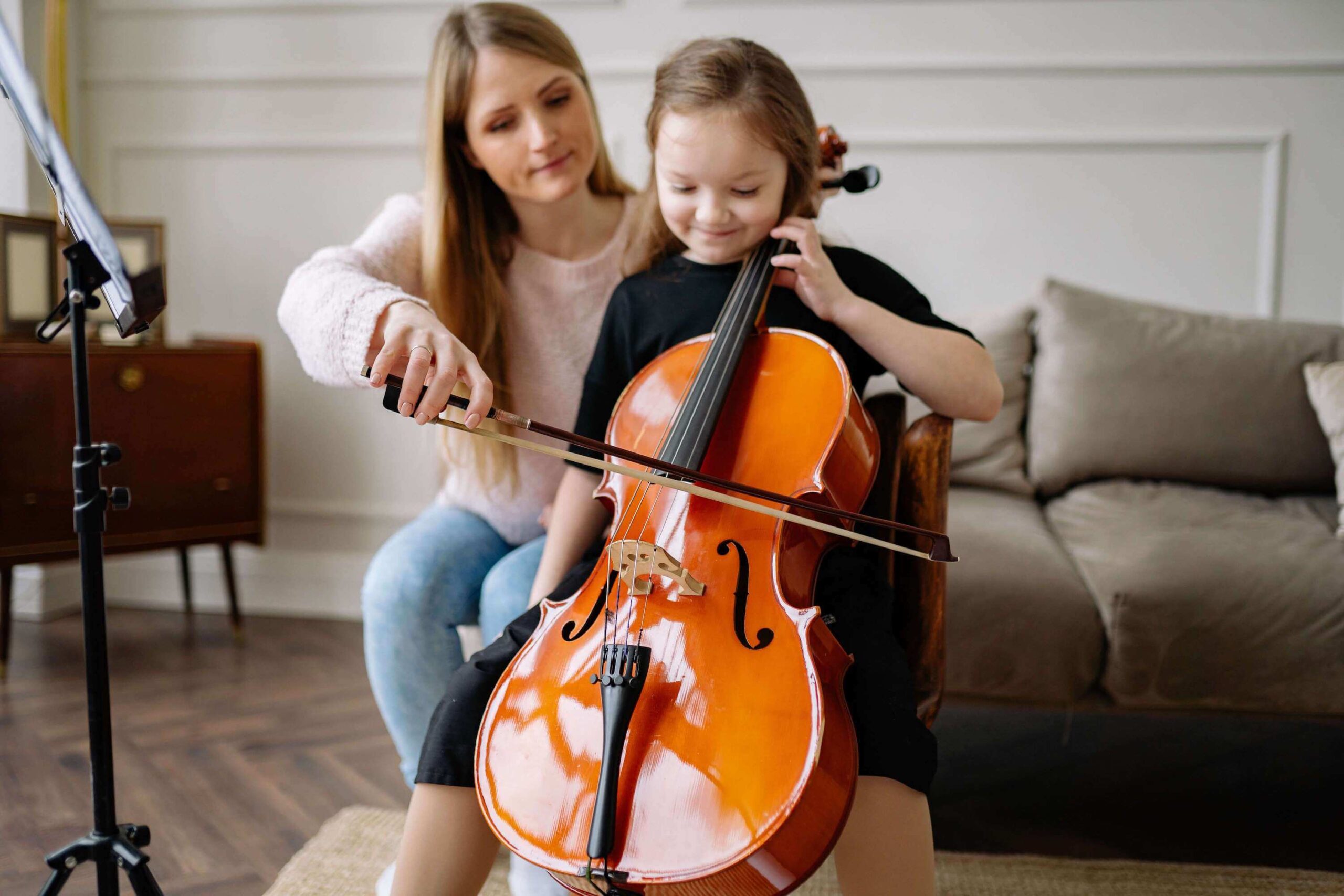 student learning to play the cello at home with a cello teacher