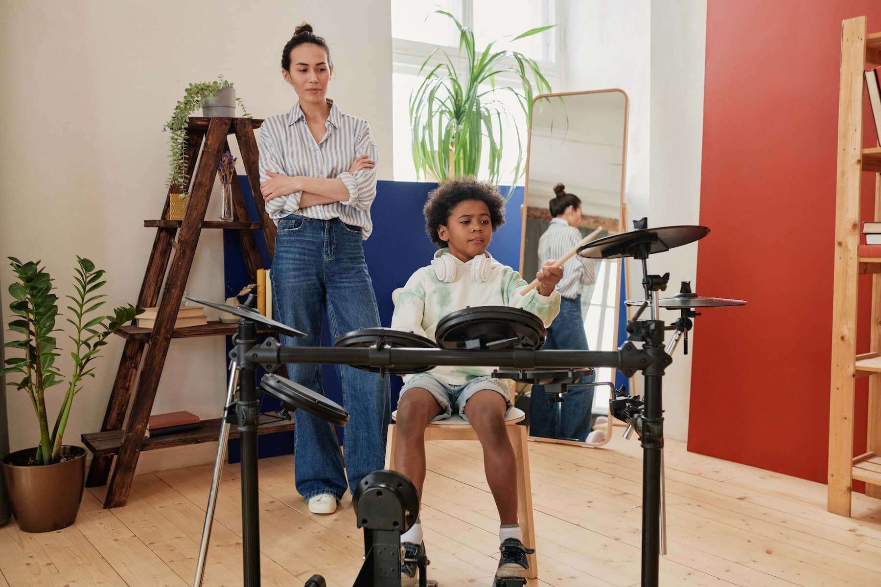 student learning to play the drums at home with a drum teacher 