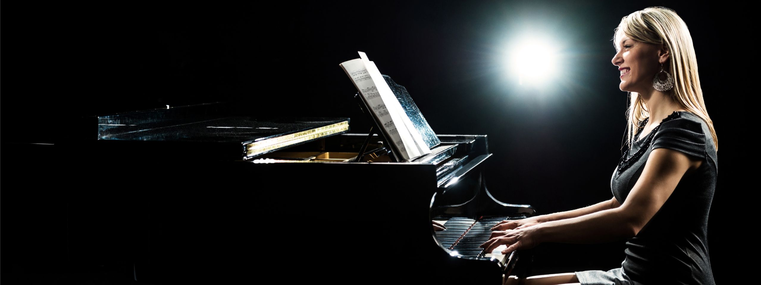 woman playing piano smiling