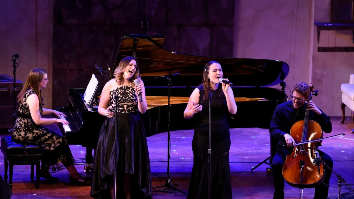 group of performers on stage including a pianist, two singers, and a cellist.