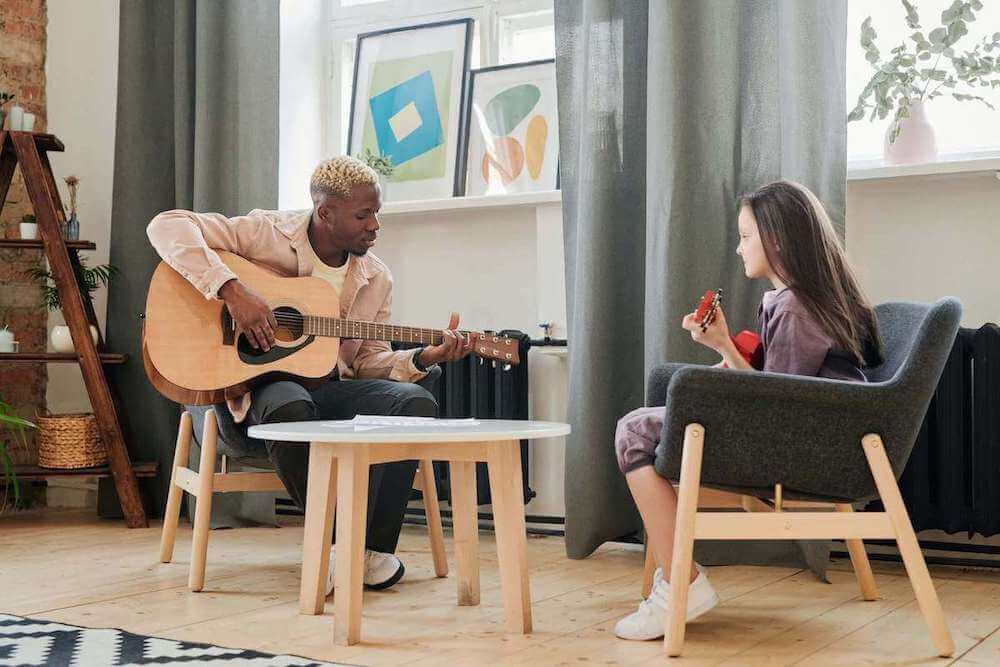 guitar teacher teaching the young student to play the guitar