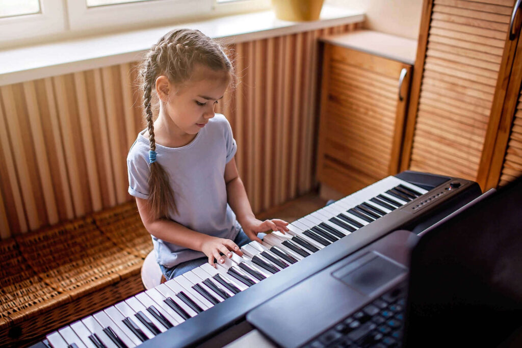young student playing the keyboard at home