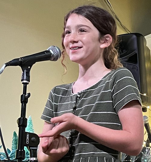 Girl smiling and singing at microphone
