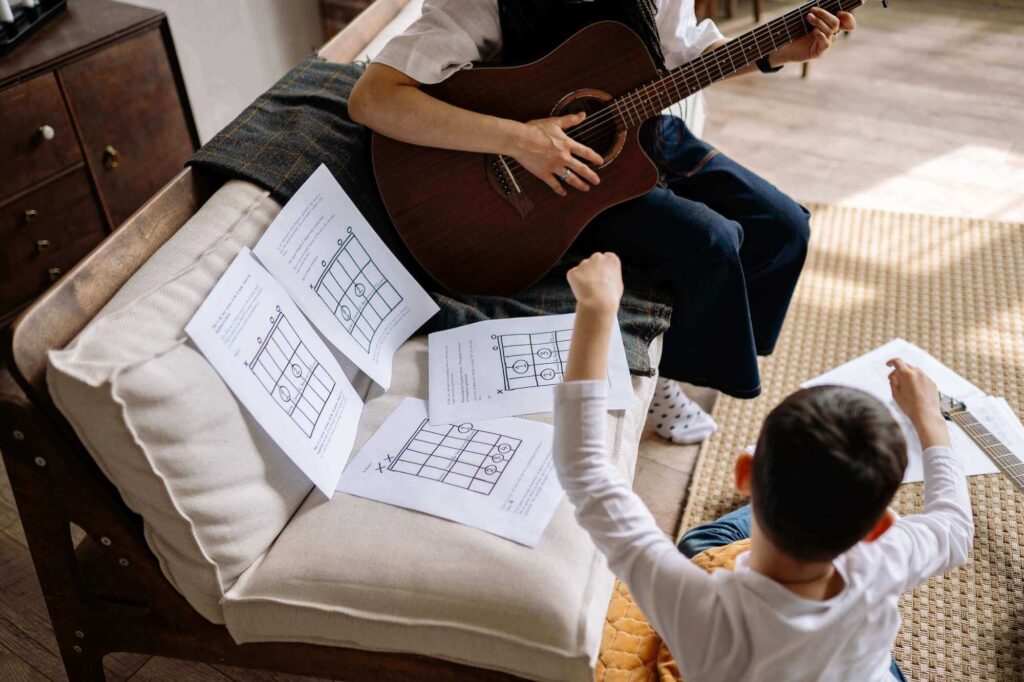 student learning to play the guitar at home