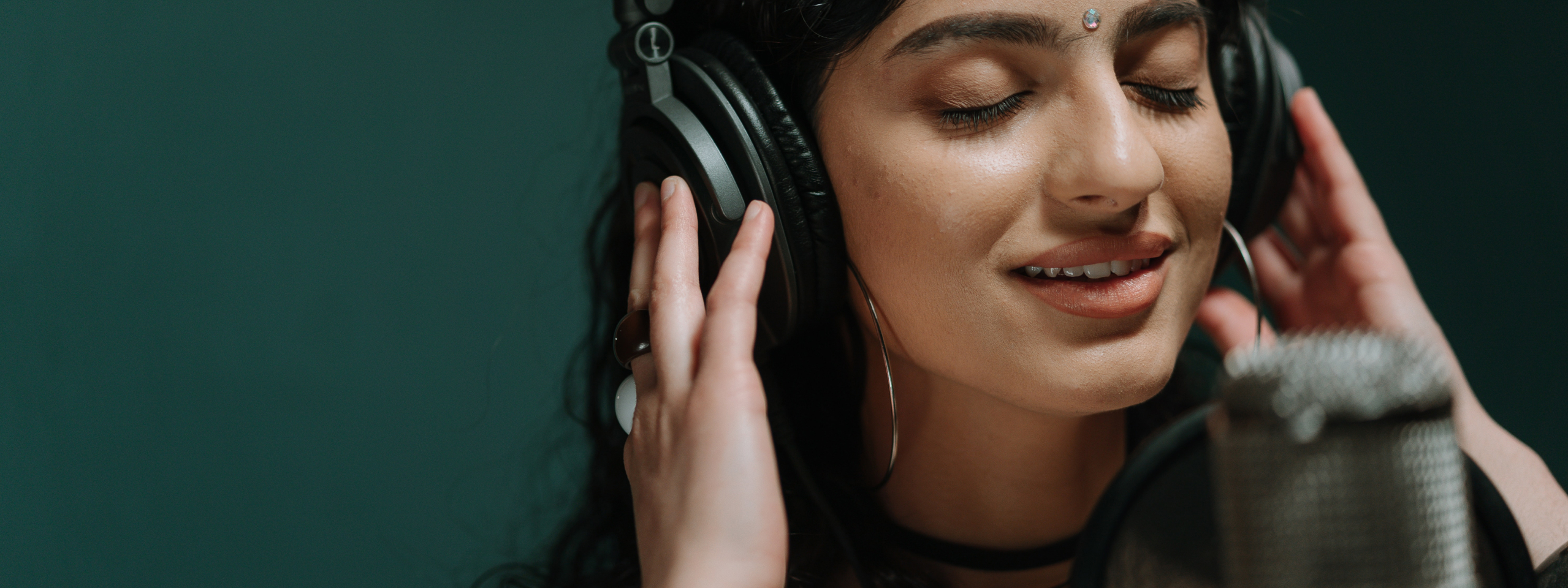 voice student singing into a microphone in a studio in Geneva, IL