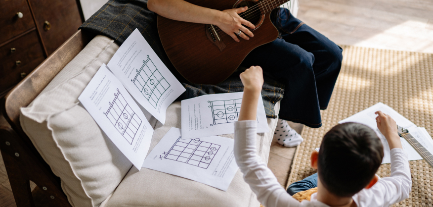 guitar teacher teaching the kid play the guitar at home Danville CA