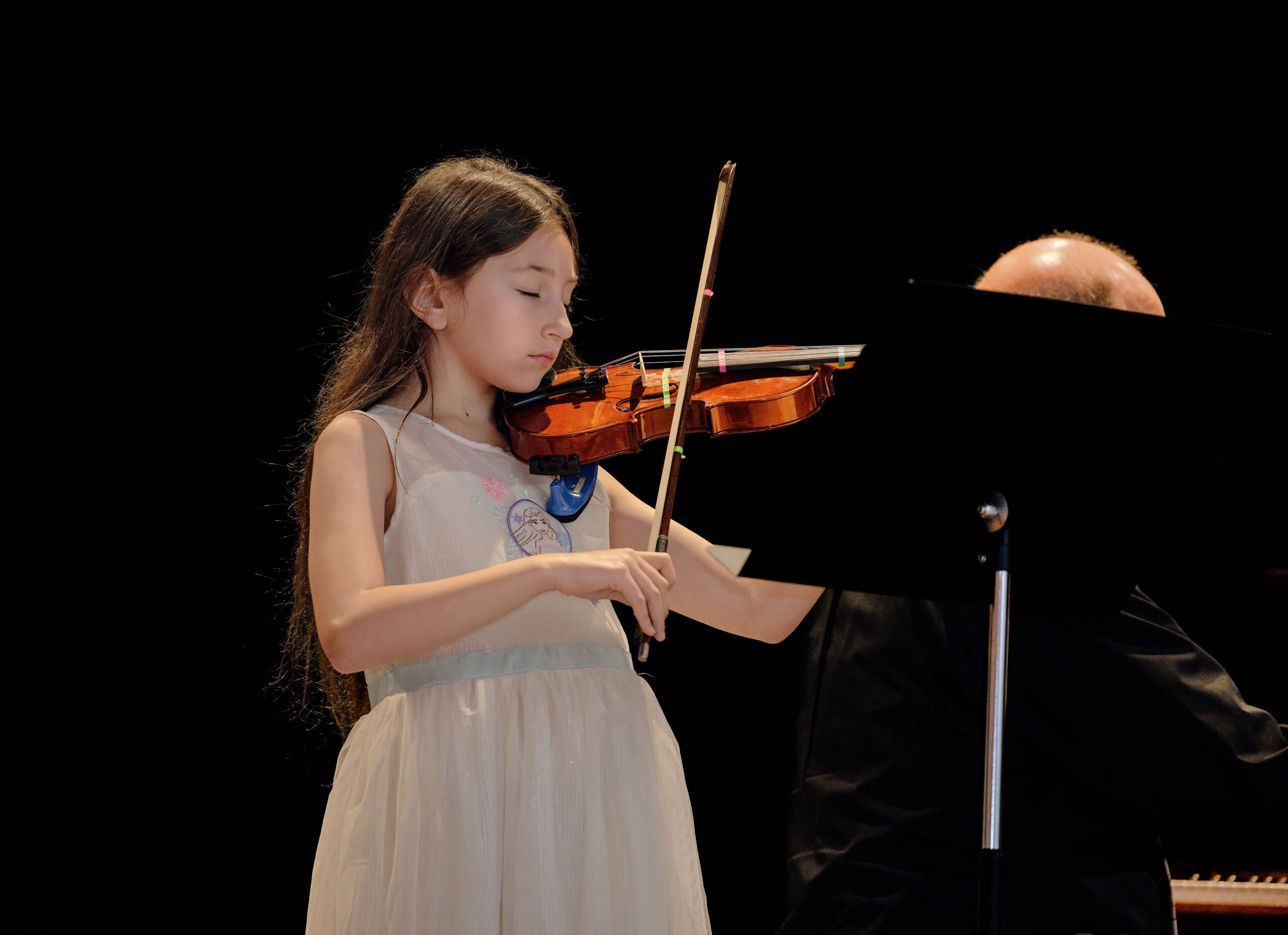 Young girl playing the violin on stage