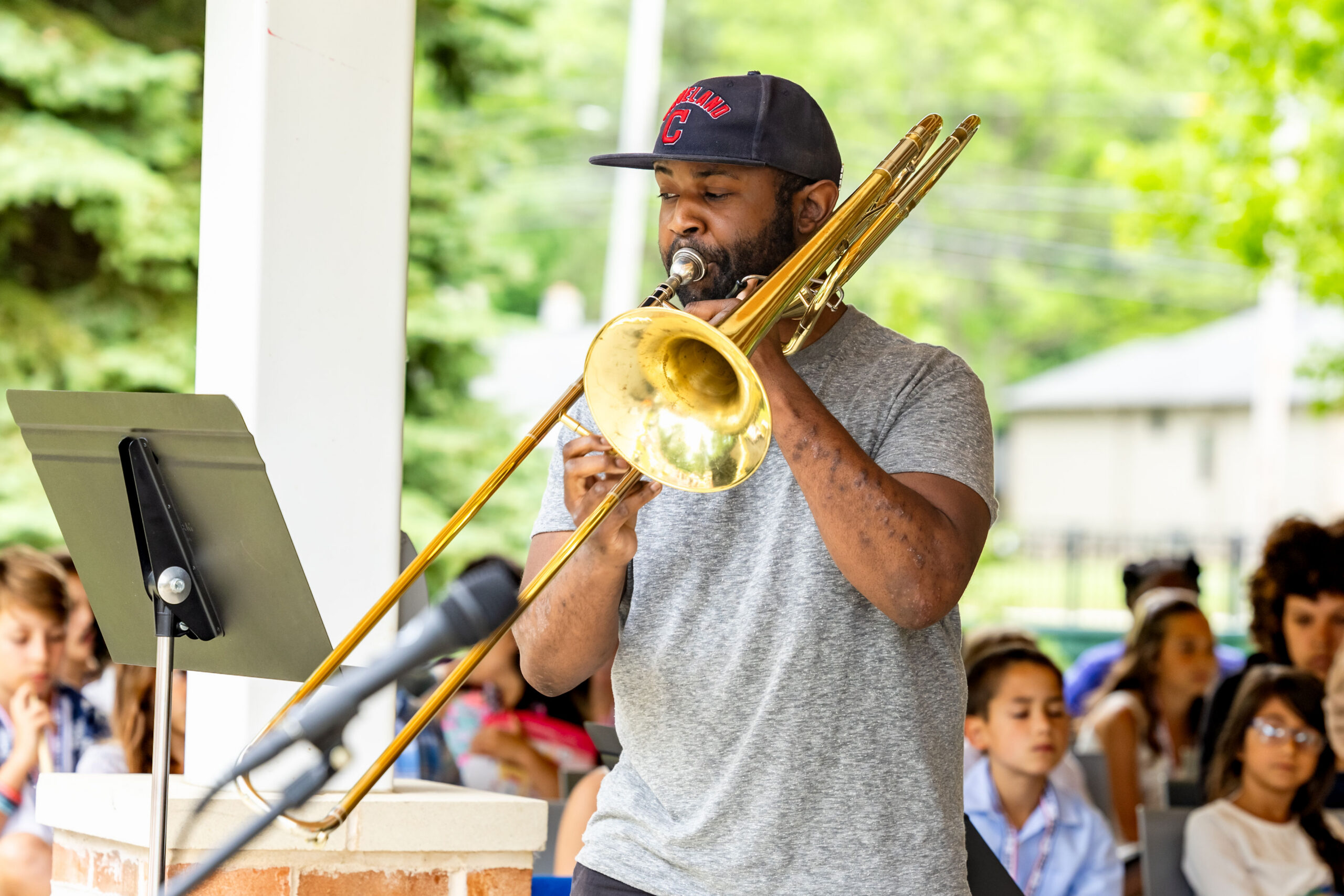 Man in a baseball hat playing the trombone