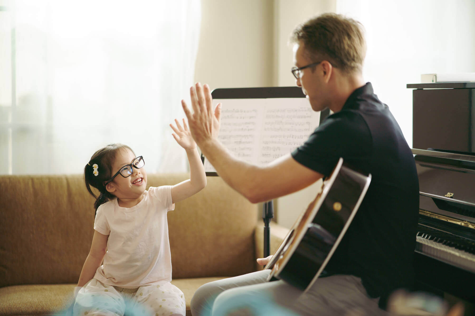 guitar teacher and the student giving high fives