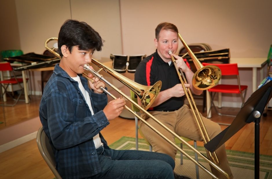 two trombone players performing together