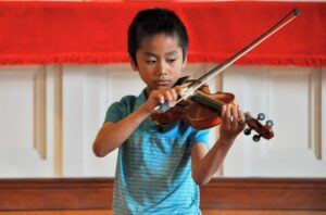 boy playing violin at a recital