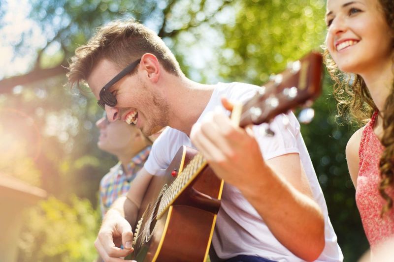 people playing the guitar in the park