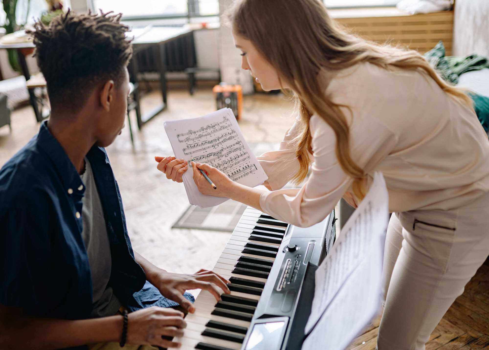 piano teacher and the piano student learning musical notes at home in Woodlands, TX