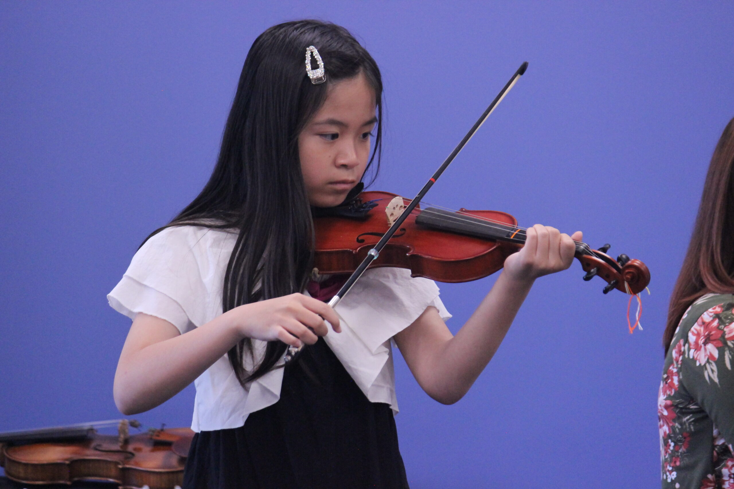 Girl with long black hair playing the violin