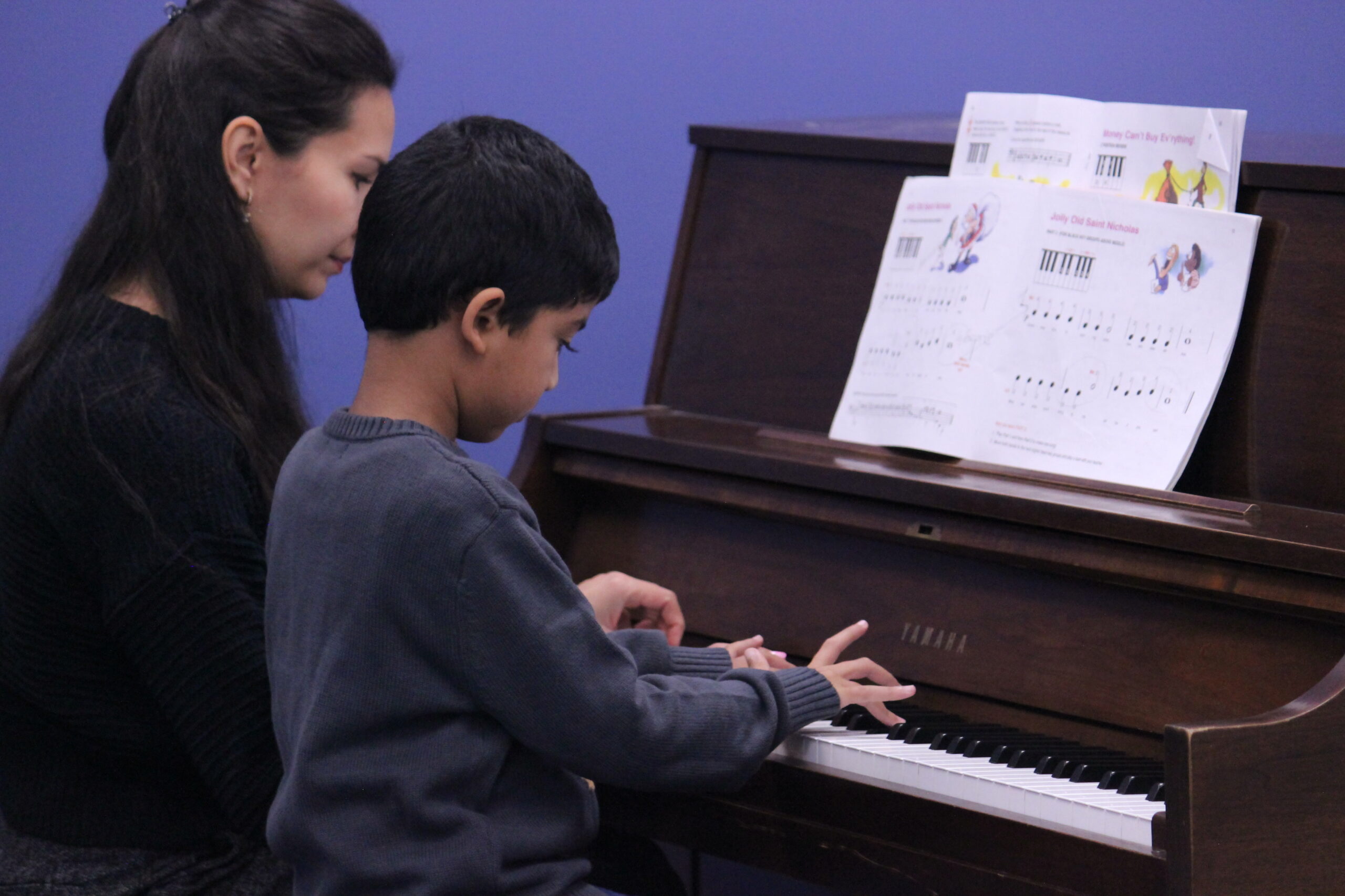 Student and teacher sitting at piano