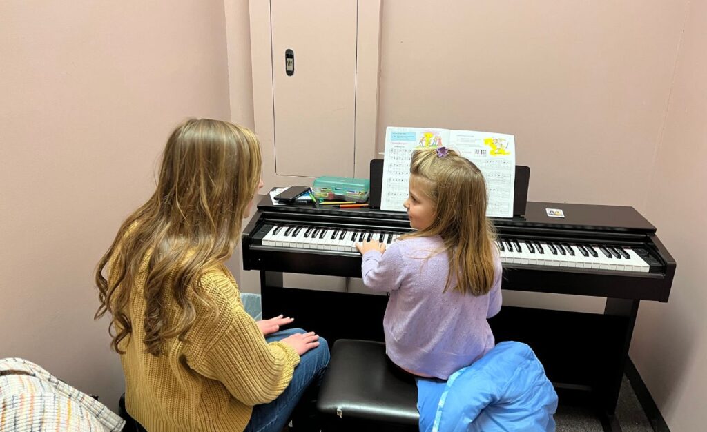 piano teacher teaching the kid play the guitar at home in SOUTH ELGIN, IL