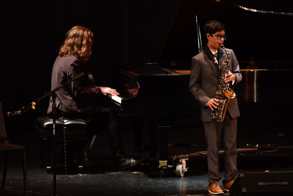 saxophone student with piano accompanist at a recital