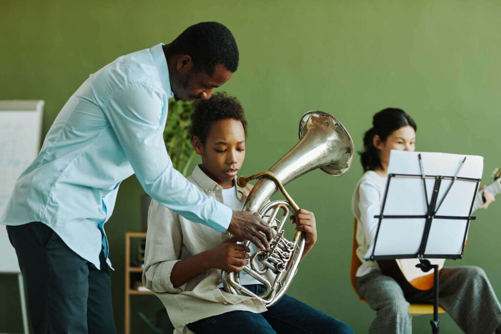 Student learning to play the French horn at the music lesson