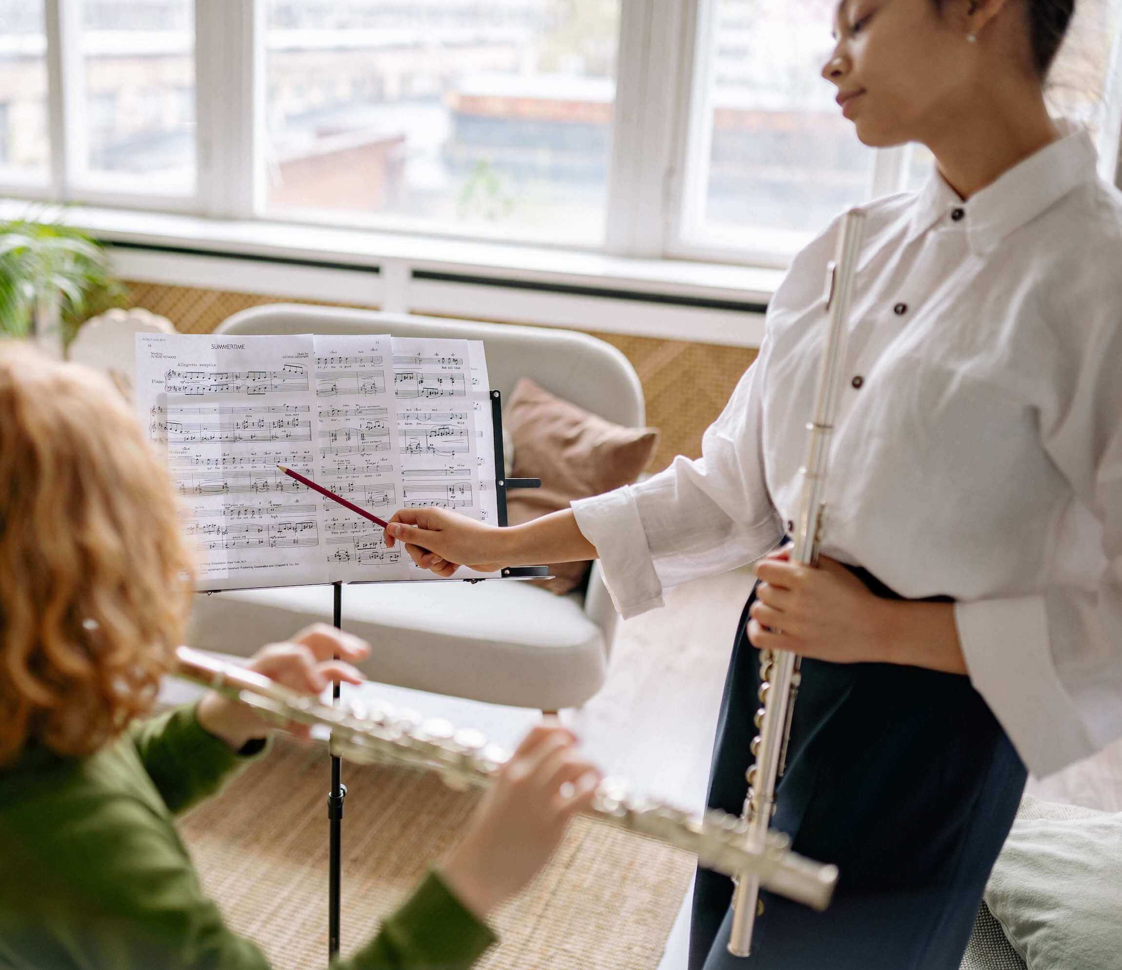 music teacher teaching the young kid how to play the flute