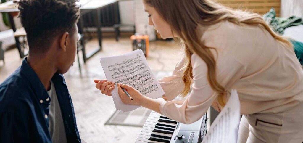 piano teacher showing musical notes to the student