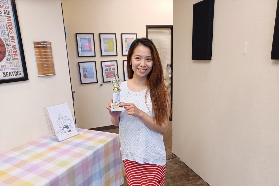 adult student holding mls trophy
