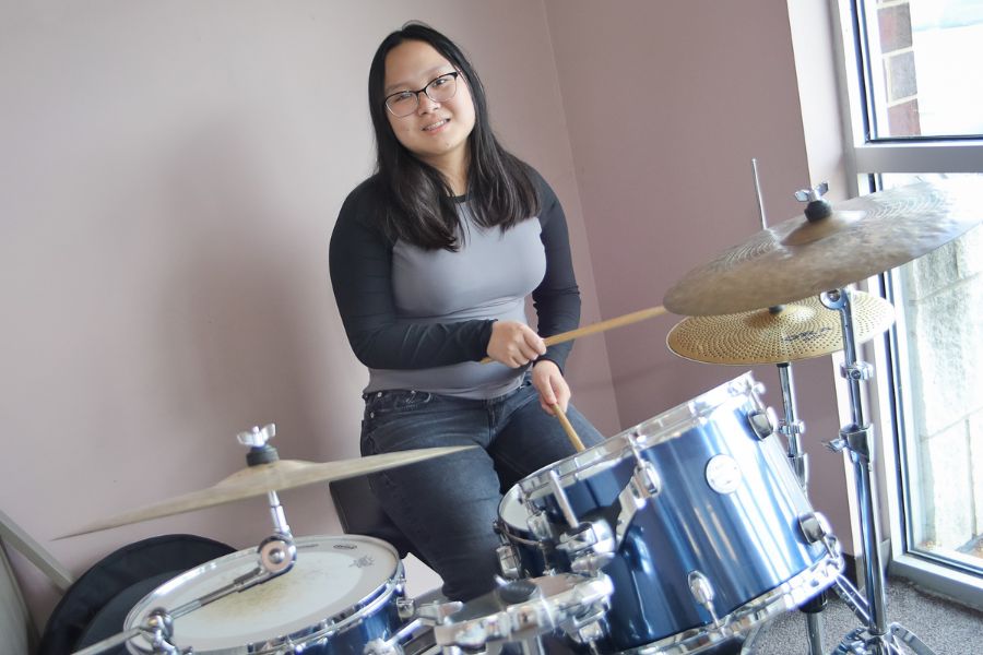 girl smiling playing drums