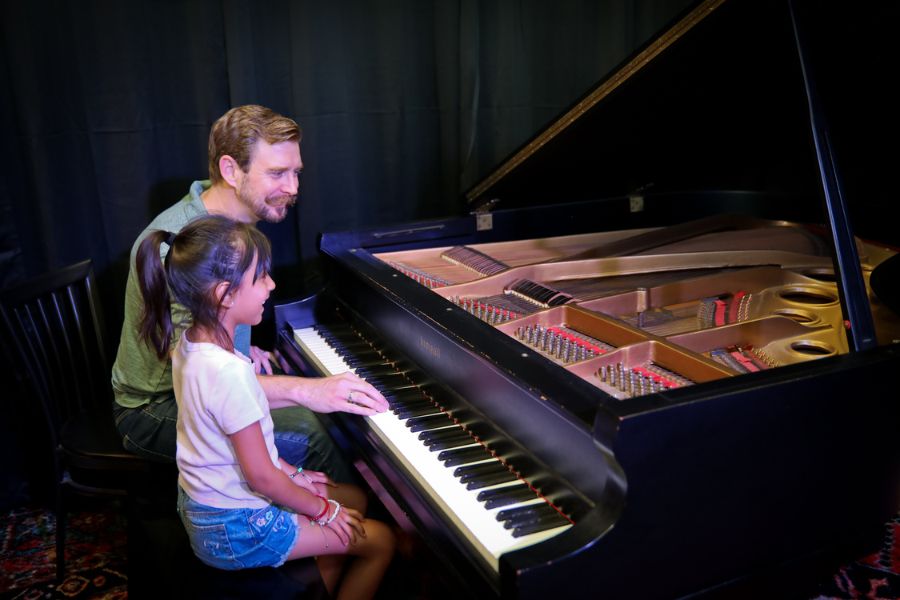 teacher and student sitting at piano