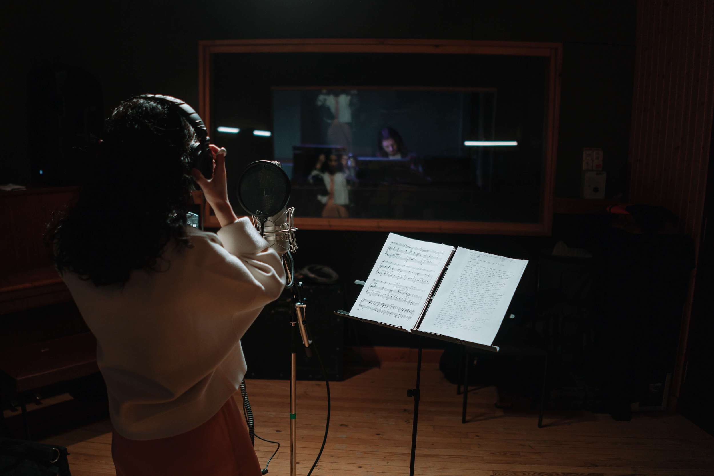 voice student singing into a microphone in a studio