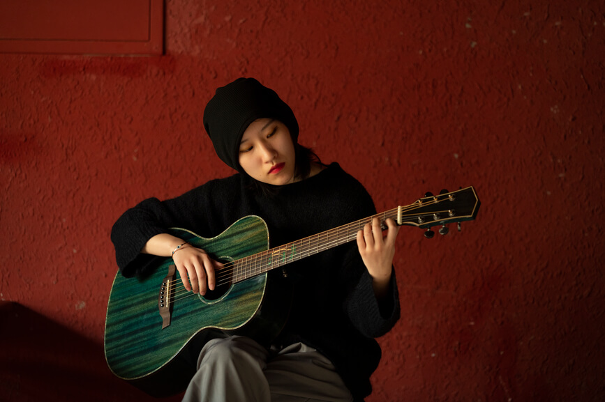 young woman playing the guitar