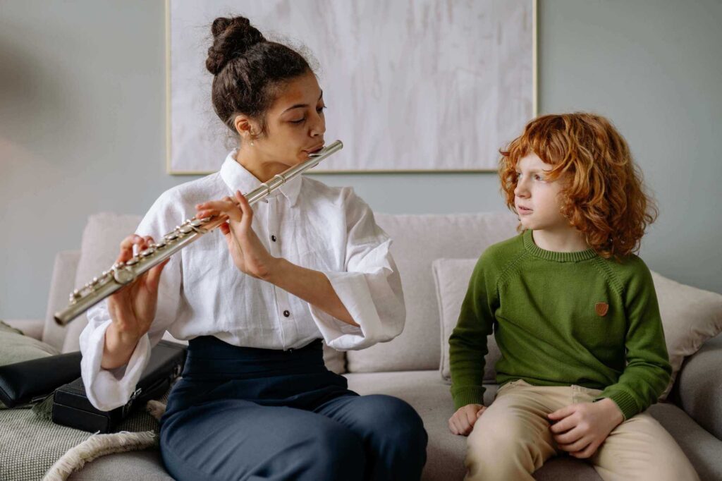 music teacher teaching the young kid how to play the flute