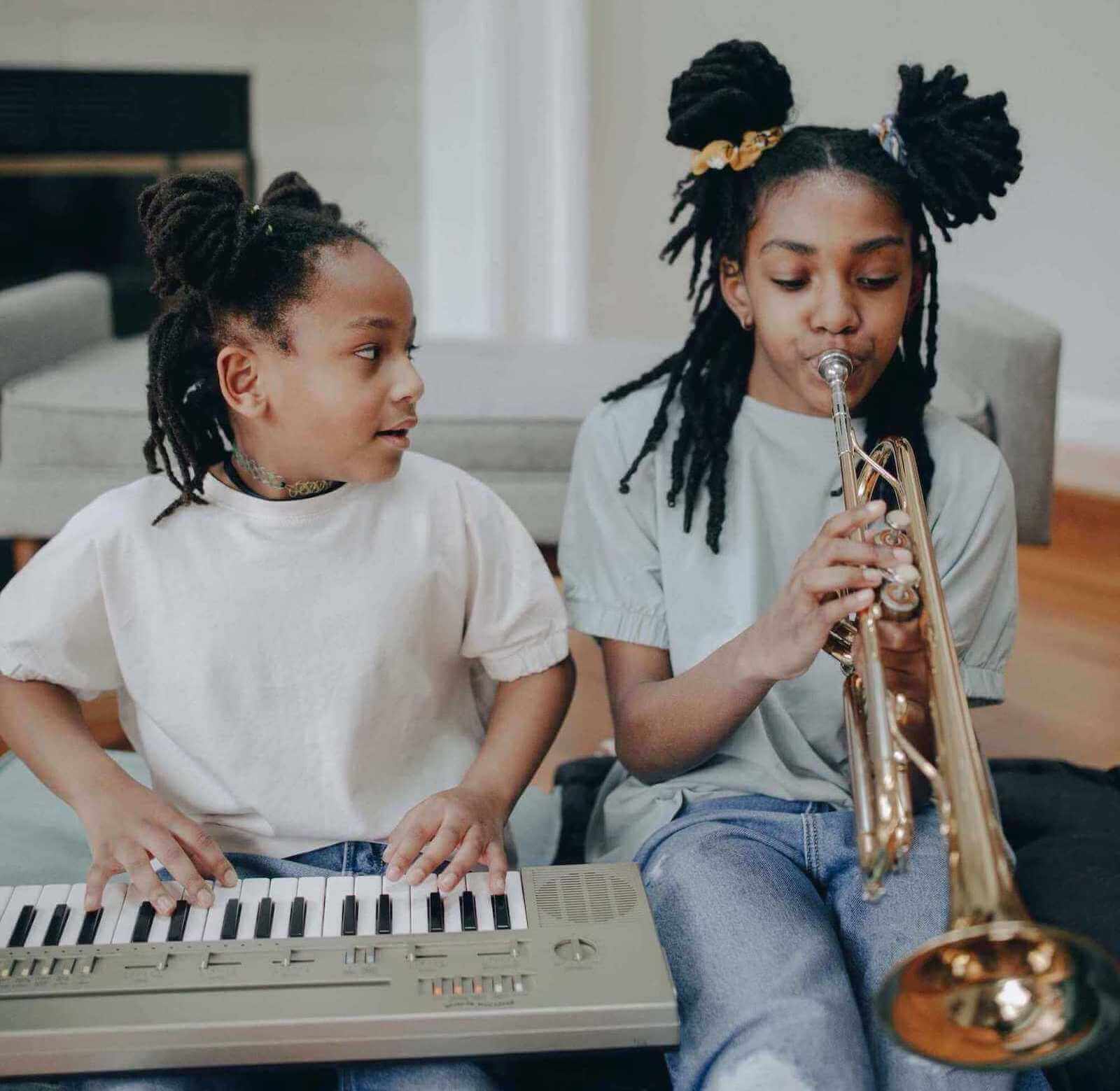 two young kids one of them playing the keyboard the other one playing the trumpet Rochester MN