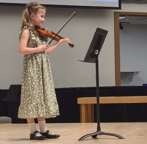 Little girl on stage playing violin