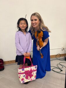 Violin teacher and student smiling at the camera
