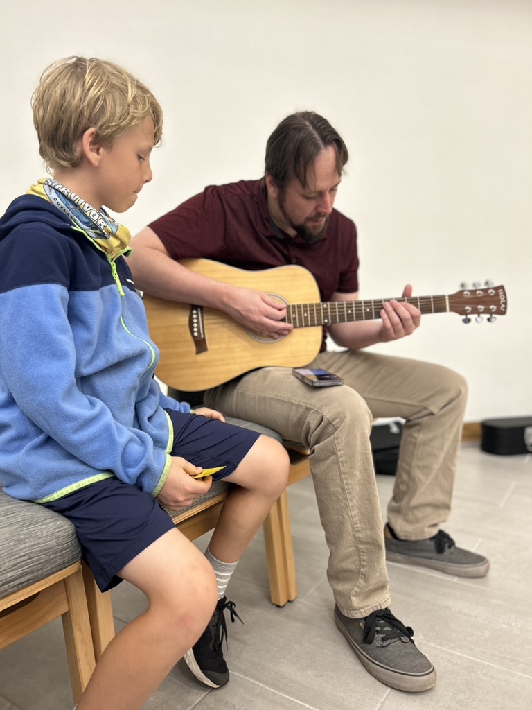 Student sitting with guitar teacher