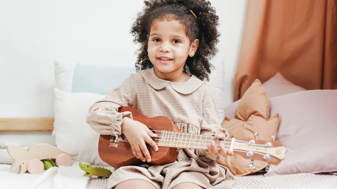 small child holding a ukulele