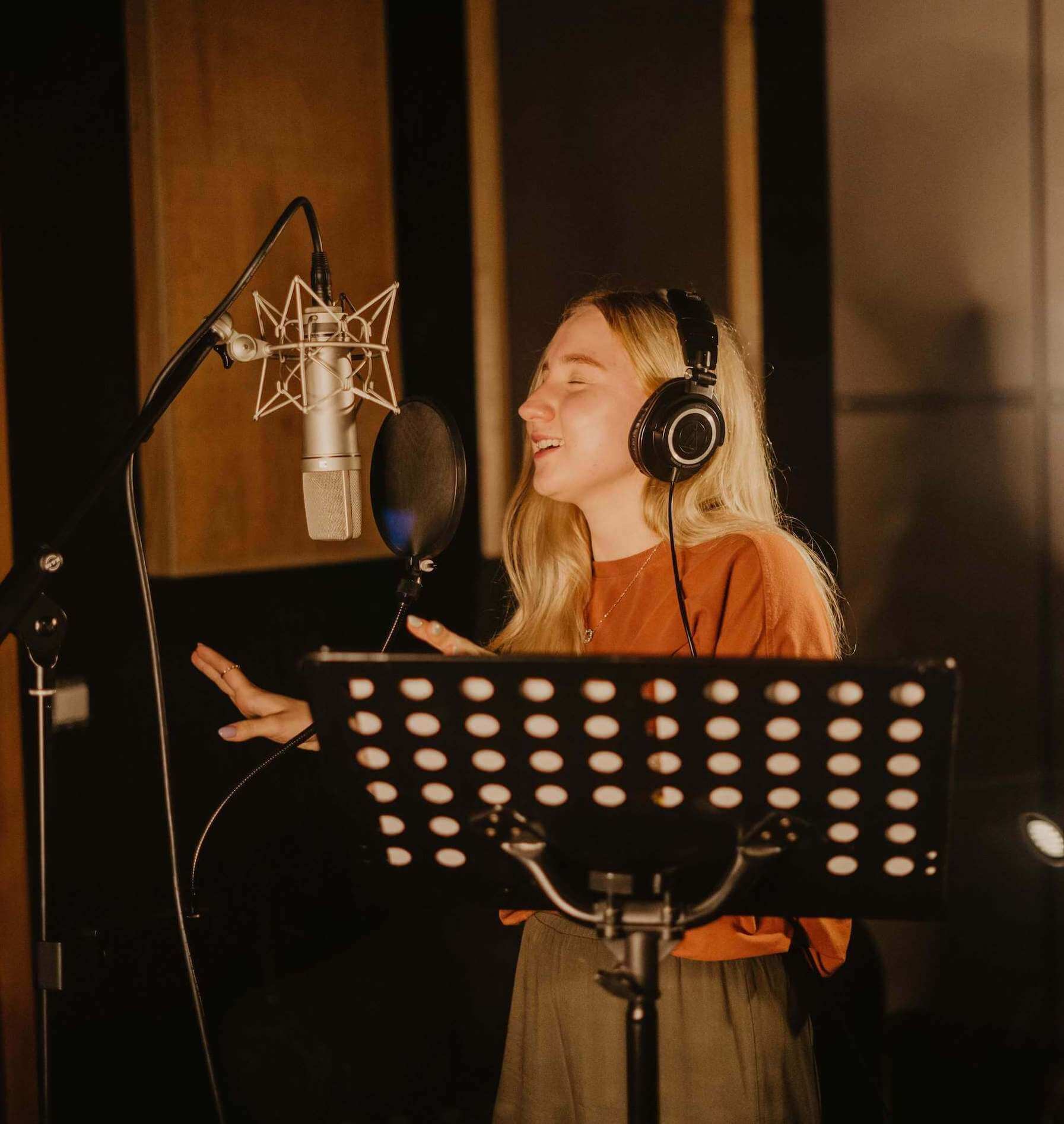 voice student singing into a microphone in a studio