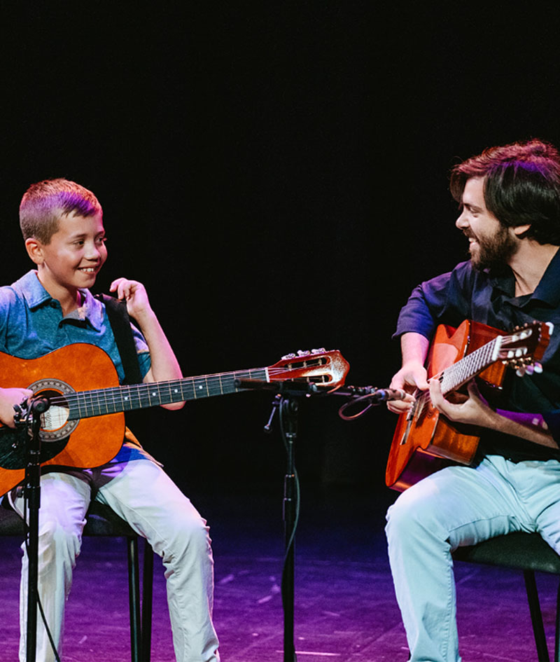 Student playing and learning guitar with teacher in Lafayette, LA